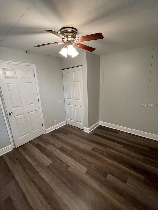 unfurnished bedroom featuring ceiling fan and dark hardwood / wood-style flooring