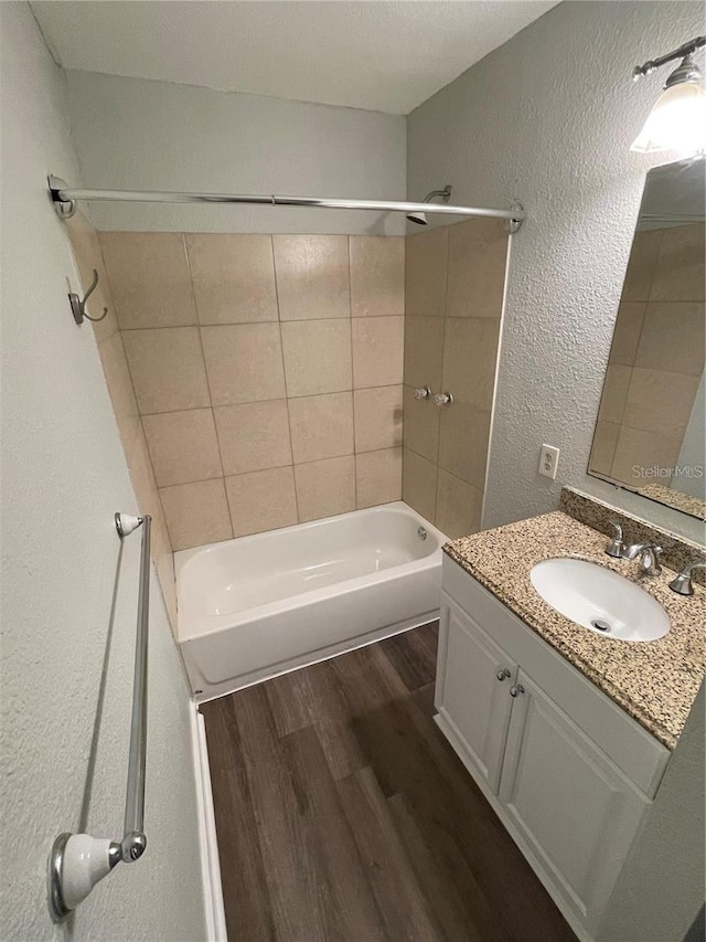 bathroom featuring vanity, tiled shower / bath, and hardwood / wood-style floors