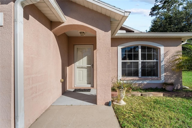 property entrance featuring a lawn