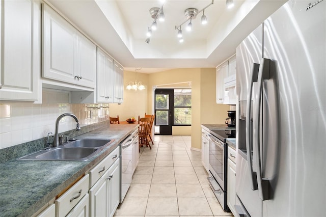 kitchen featuring pendant lighting, light tile patterned floors, a raised ceiling, white cabinetry, and appliances with stainless steel finishes