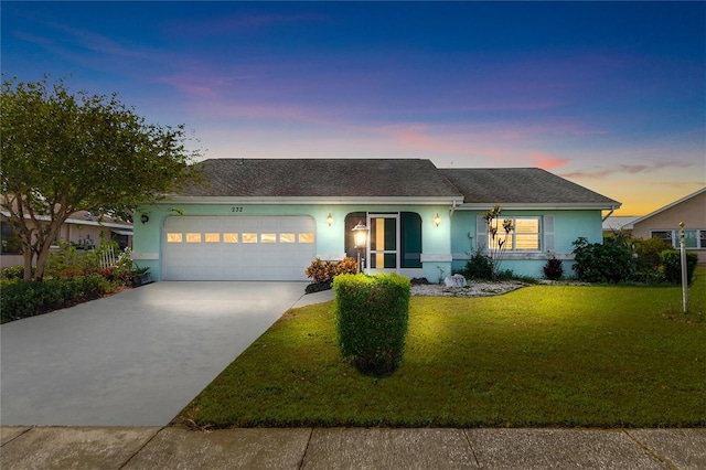 ranch-style house with a garage and a yard