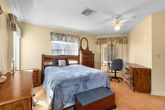 bedroom with ceiling fan, a textured ceiling, and light hardwood / wood-style flooring