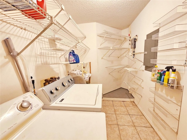 laundry area featuring tile patterned flooring, washing machine and dryer, and a textured ceiling