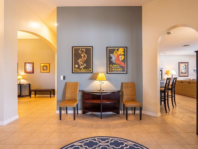 interior space with light tile patterned floors and vaulted ceiling