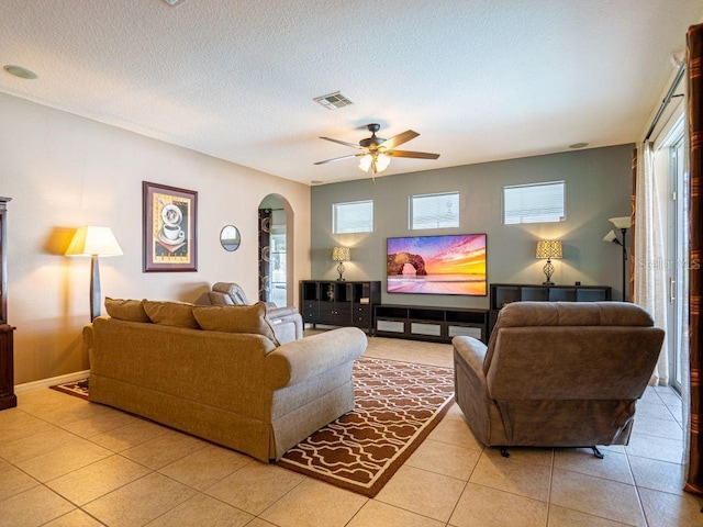 living room with light tile patterned floors, a textured ceiling, and ceiling fan