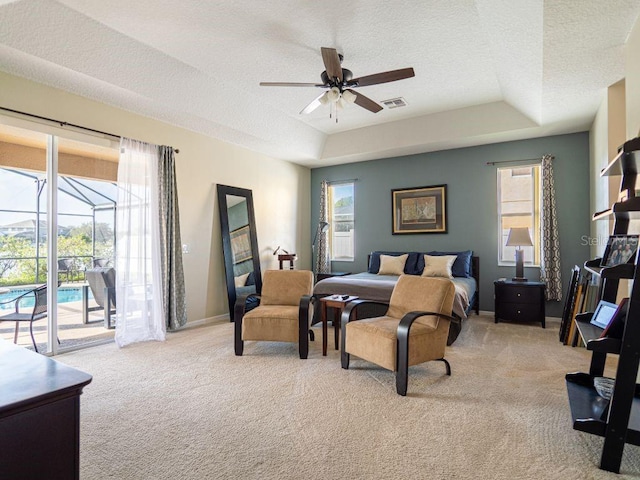 carpeted bedroom featuring a textured ceiling, access to outside, a raised ceiling, and ceiling fan