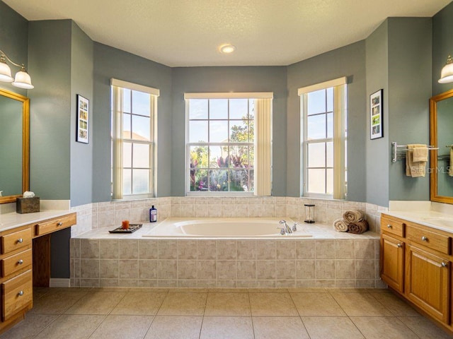 bathroom featuring tile patterned floors, tiled bath, and vanity