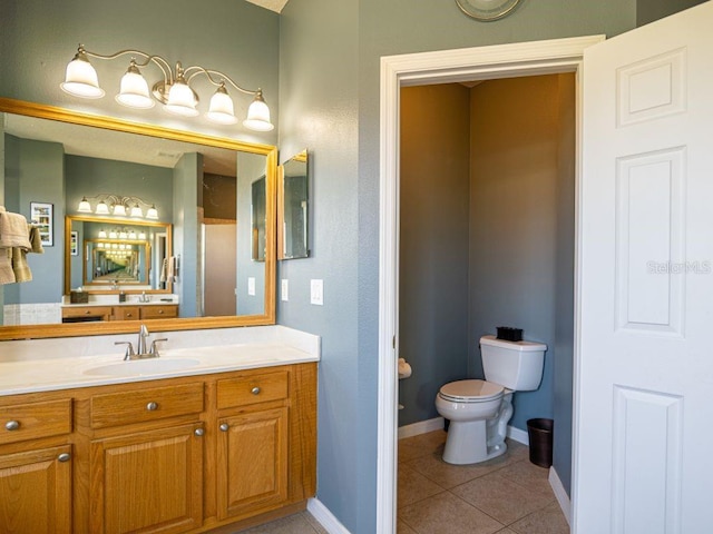 bathroom with tile patterned flooring, vanity, and toilet