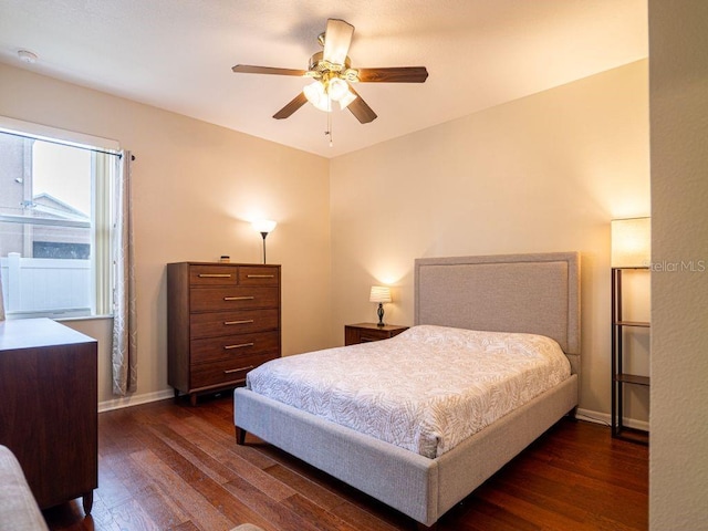 bedroom with dark hardwood / wood-style flooring and ceiling fan