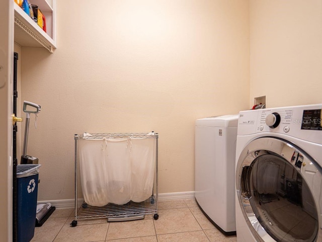 laundry area featuring light tile patterned floors and separate washer and dryer