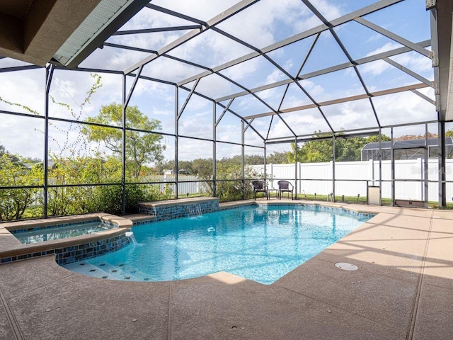 view of swimming pool featuring an in ground hot tub, pool water feature, glass enclosure, and a patio area