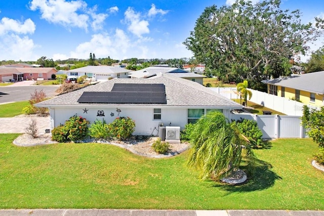 view of side of home featuring solar panels and a lawn