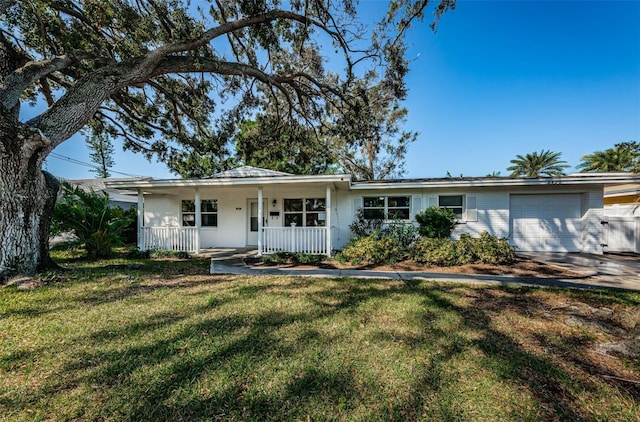 ranch-style house featuring a porch, a front yard, and a garage