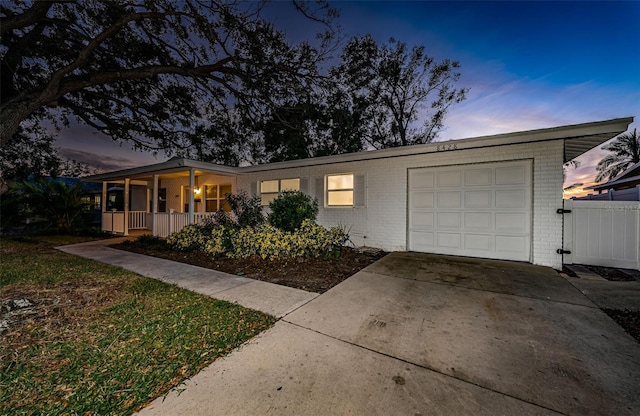 ranch-style home featuring covered porch and a garage