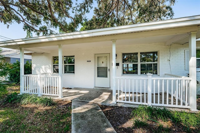 view of front of home with covered porch and brick siding