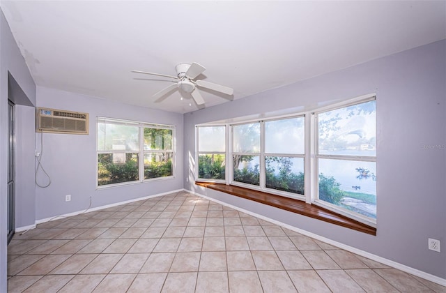 unfurnished sunroom with ceiling fan and a wall mounted AC