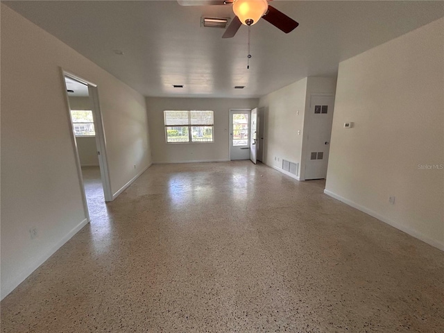 unfurnished room featuring baseboards, ceiling fan, and visible vents