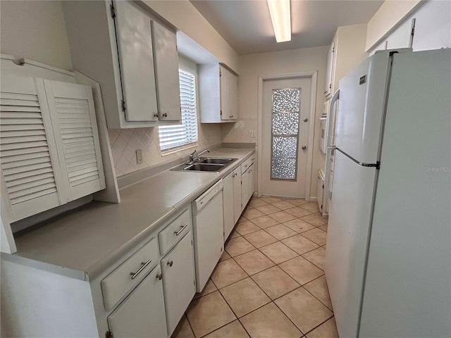 kitchen with a sink, light countertops, white cabinets, and white appliances