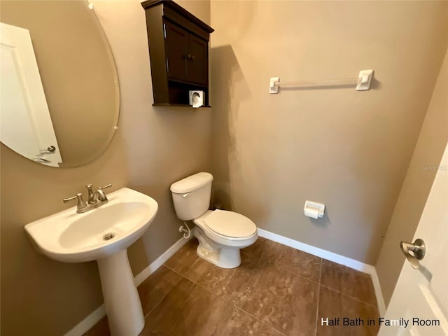 bathroom with toilet and tile patterned flooring