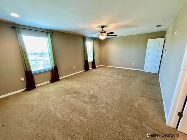 carpeted spare room featuring ceiling fan