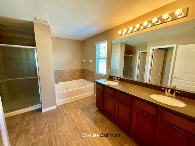 bathroom featuring vanity, a textured ceiling, and separate shower and tub