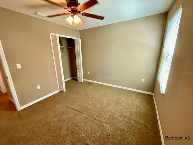 unfurnished bedroom featuring a closet, carpet, and ceiling fan