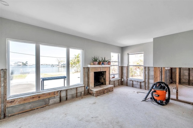 living room with a water view and a stone fireplace