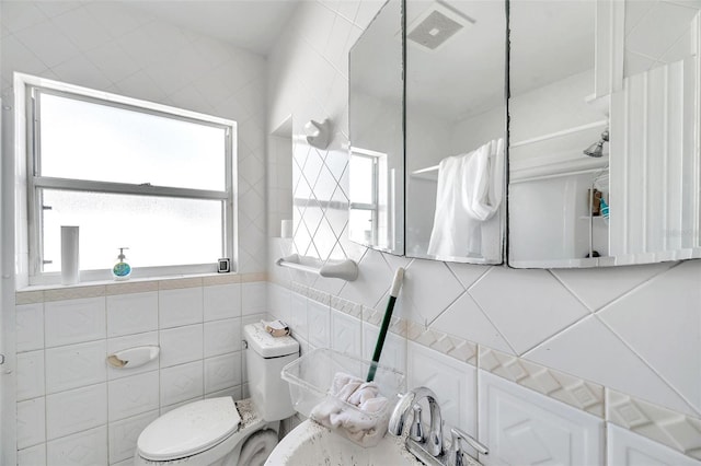 bathroom with tile walls and toilet