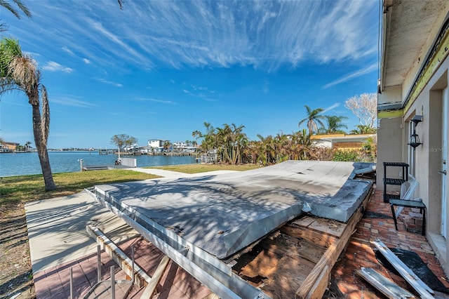 wooden terrace with a patio and a water view