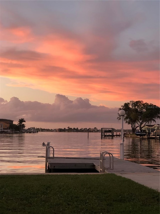 dock area with a water view and a lawn