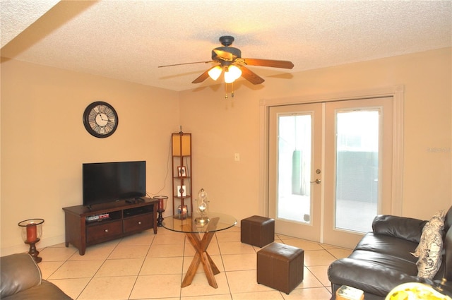 tiled living room with ceiling fan, a textured ceiling, and french doors