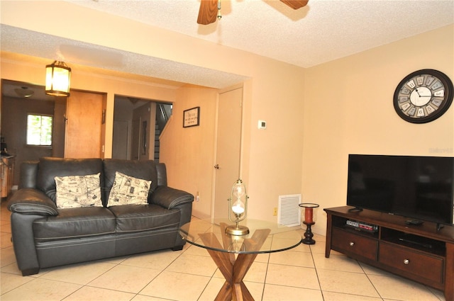 tiled living room featuring a textured ceiling and ceiling fan