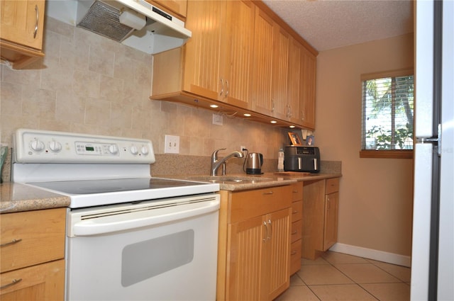 kitchen featuring white range with electric stovetop, tasteful backsplash, sink, light tile patterned floors, and a textured ceiling