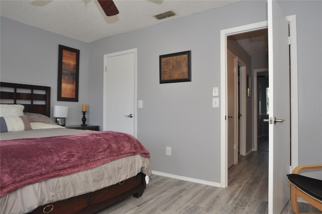 bedroom featuring a textured ceiling, ceiling fan, and hardwood / wood-style flooring