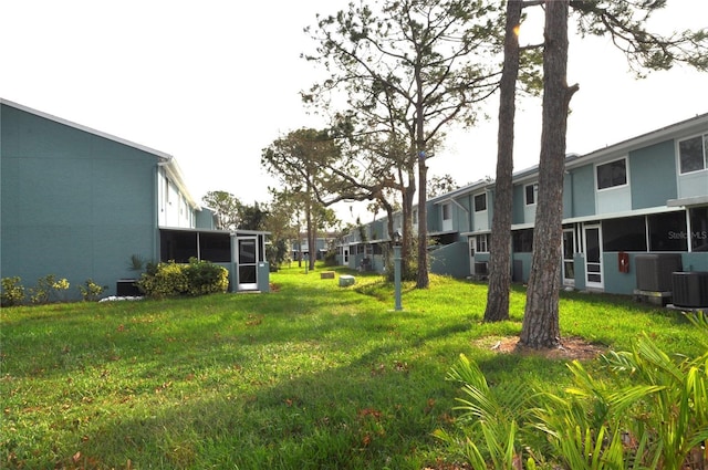 view of yard featuring a sunroom and central AC