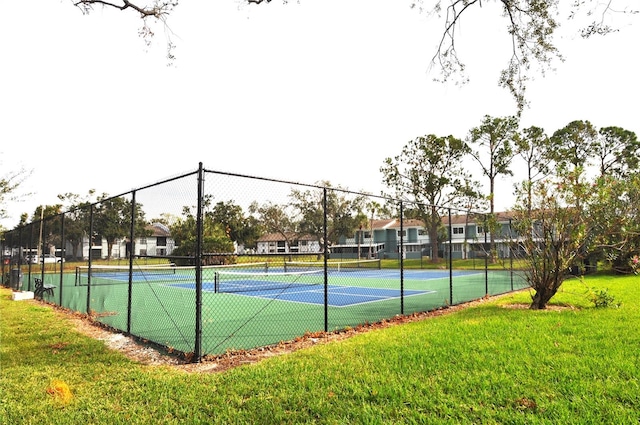 view of tennis court with a yard