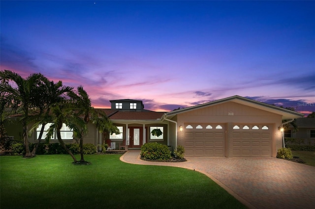 view of front of home featuring a garage and a yard