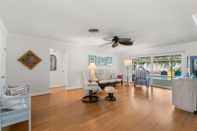 living room with ceiling fan, crown molding, and light hardwood / wood-style flooring