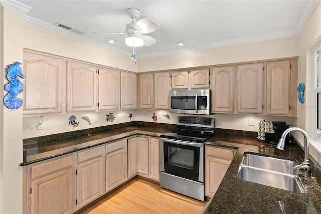 kitchen with dark stone countertops, light brown cabinetry, sink, and appliances with stainless steel finishes