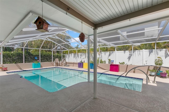 view of pool with glass enclosure and a patio