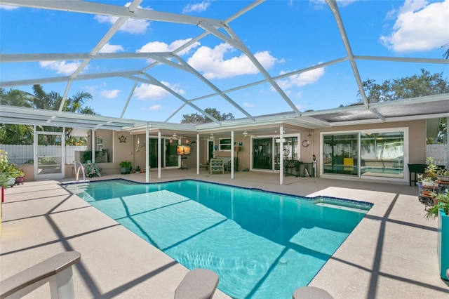 view of swimming pool with a patio area, ceiling fan, and a lanai