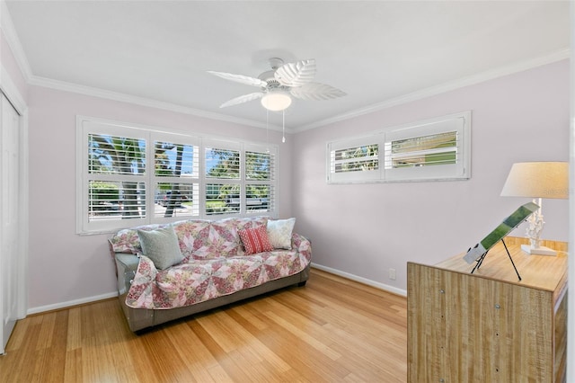 living area with plenty of natural light, ceiling fan, wood-type flooring, and ornamental molding