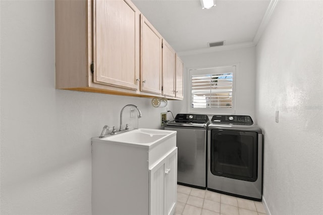 washroom with washing machine and dryer, crown molding, light tile patterned flooring, and cabinets