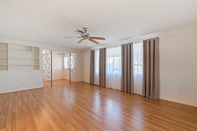 unfurnished room with light hardwood / wood-style flooring, built in features, and ceiling fan