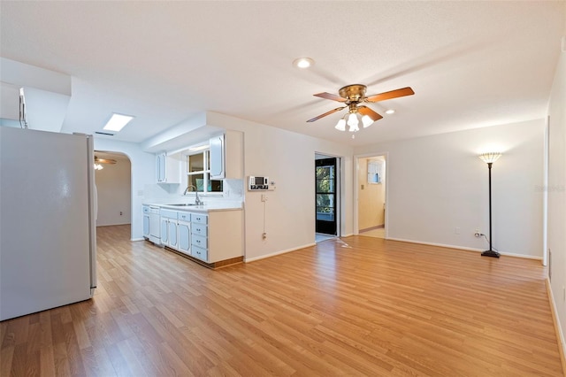 kitchen featuring light hardwood / wood-style floors, sink, white cabinets, white appliances, and ceiling fan