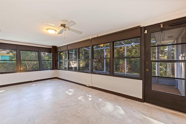 unfurnished sunroom featuring a wealth of natural light and ceiling fan