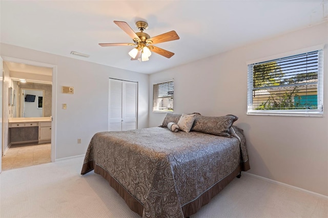 carpeted bedroom with connected bathroom, a closet, and ceiling fan