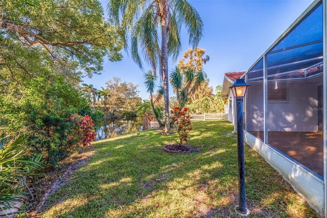 view of yard featuring a lanai and a water view