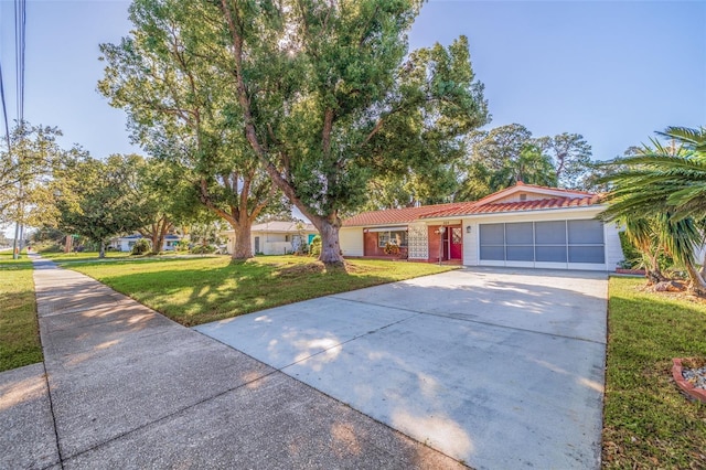 ranch-style house featuring a front lawn and a garage