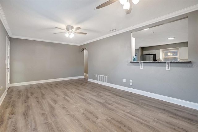 spare room with ceiling fan, crown molding, and light hardwood / wood-style flooring